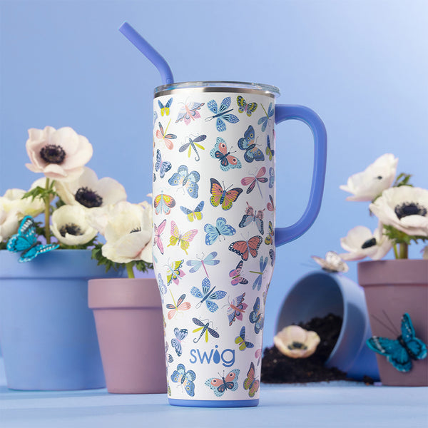 Swig Life Insulated Butterfly Bliss 40oz Mega Mug surrounded by white flowers and blue butterflies