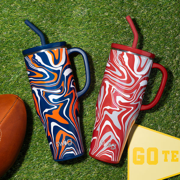 Swig Life Fanzone Navy + Orange and Fanzone Crimson 40oz Mega Mugs on a green grassy field