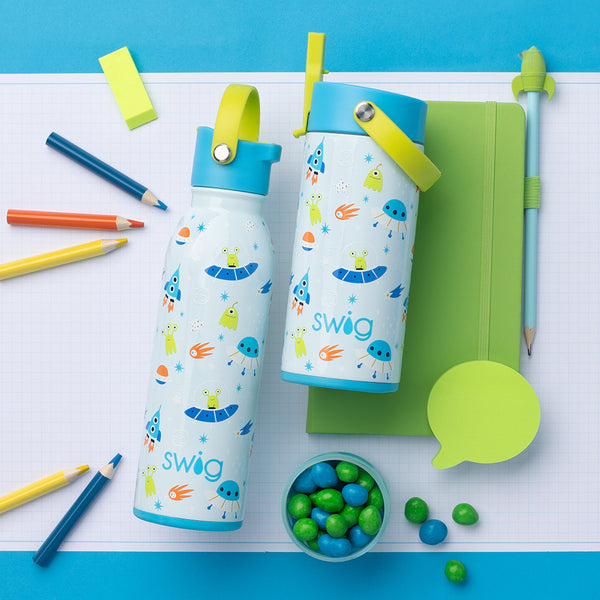 Swig Life Space Camp 16oz Flip + Sip Bottle and 12oz Flip + Sip Slim Tumbler in a school setting with a notebook and pens