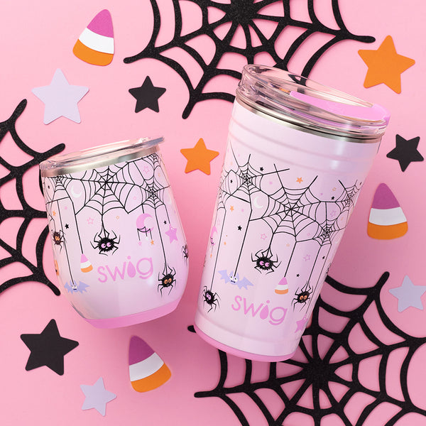 Swig Life Sweet and Spooky Insulated 24oz Party Cup and 12oz Stemless Wine Cup on a pink Halloween background with spider webs